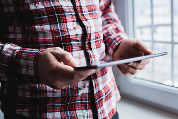 Image showing The man uses a tablet PC. Modern gadget in hand.