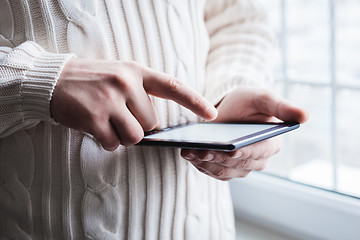 Image showing The man uses a tablet PC. Modern gadget in hand.