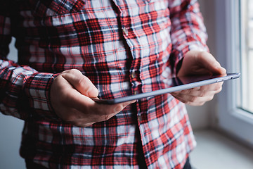 Image showing The man uses a tablet PC. Modern gadget in hand.