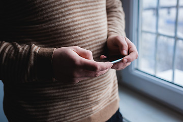 Image showing The man is using a smartphone. Modern mobile phone in hand.