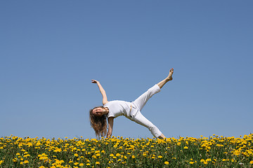 Image showing Smiling young woman exercising in dandelion field