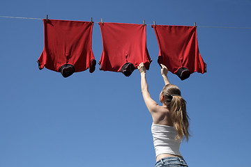 Image showing Girl, blue sky and red laundry