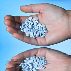 Image showing hand holding blue pills