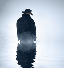 Image showing person wearing trench coat and standing in water