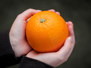 Image showing Orange in the hands of a child 