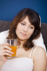 Image showing Drinking orange juice on bed