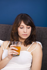 Image showing Drinking orange juice on bed