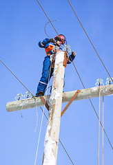 Image showing electrician working on top of an electricity pylon 