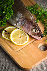 Image showing Pike perch on a wooden kitchen board, it is isolated on white