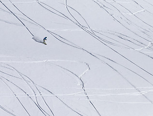 Image showing Snowboarder downhill on off piste slope with newly-fallen snow