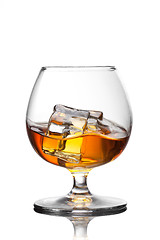 Image showing Splash of whiskey with ice in glass isolated on white background