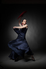 Image showing young woman dancing flamenco on black