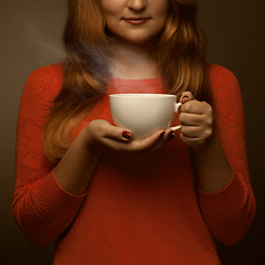 Image showing woman holding hot cup and smiles