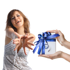 Image showing A girl reaching out for men's hands holding a present on white b