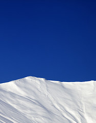 Image showing Off-piste slope and blue clear sky in sun winter day