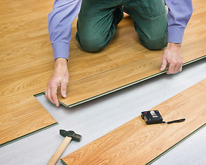 Image showing Man laying laminated panels color of wood