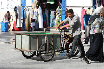 Image showing Man pushing a tricycles