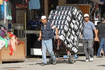 Image showing Men pushing a trolley