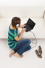 Image showing Listen music and using  a laptop