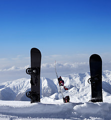 Image showing Three snowboards in snow near off piste slope in sun day