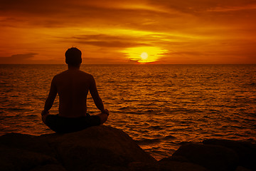 Image showing Man meditating at sunset. Tropical beach of Thailand