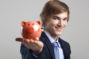 Image showing Holding a piggy bank