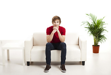 Image showing Young man sitting on the couch