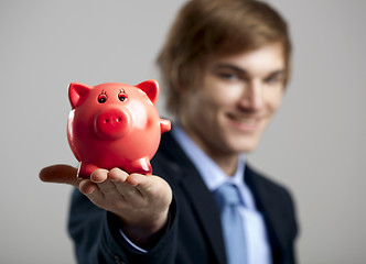Image showing Holding a piggy bank