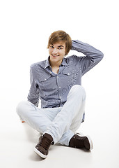 Image showing Young man sitting on the floor