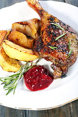 Image showing Duck leg with potatoes and cowberry sauce. 