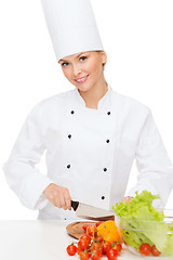 Image showing smiling female chef chopping vagetables