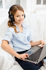 Image showing girl with laptop computer and headphones at home