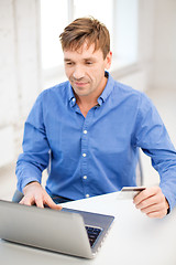 Image showing man with laptop and credit card at home