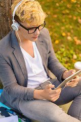 Image showing smiling male student in eyeglasses with tablet pc