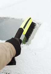 Image showing closeup of man cleaning snow from car