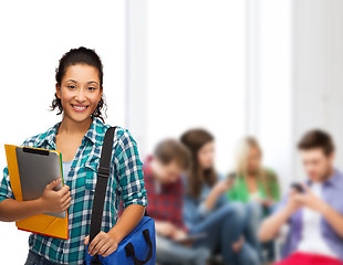 Image showing smiling student with folders, tablet pc and bag