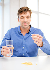 Image showing man at home showing lot of pills