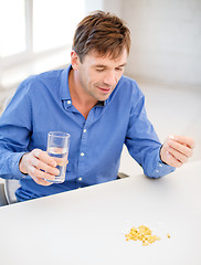 Image showing ill man taking his pills at home