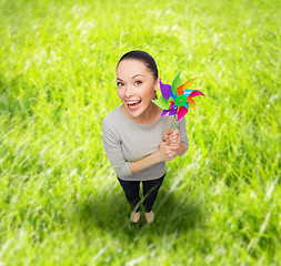 Image showing smiling asian woman with windmill