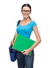 Image showing female student in eyeglasses with bag and folders