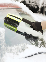 Image showing closeup of man cleaning snow from car