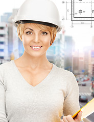 Image showing female contractor in helmet with folder