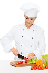 Image showing smiling female chef chopping vagetables