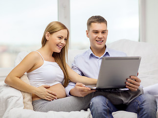 Image showing expecting family with laptop computer