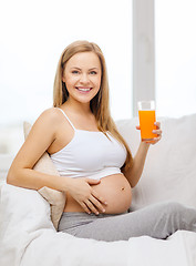 Image showing happy pregnant woman with fresh orange juice