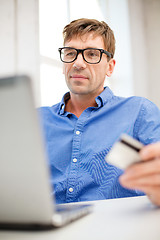 Image showing man with laptop and credit card at home