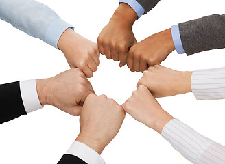 Image showing closeup of businesspeople hands in fists in circle