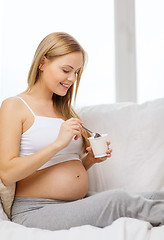 Image showing happy pregnant woman with yogurt