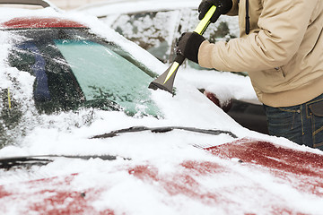 Image showing closeup of man scraping ice from car