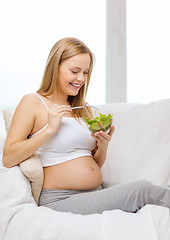 Image showing happy pregnant woman eating salad